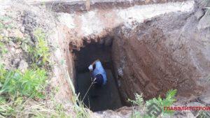 Вручную выбираем грунт под дренажные колодцы.